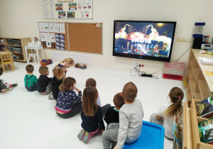 Dzieci oglądają film dotyczący tradycji bożonarodzeniowych w Indiach.